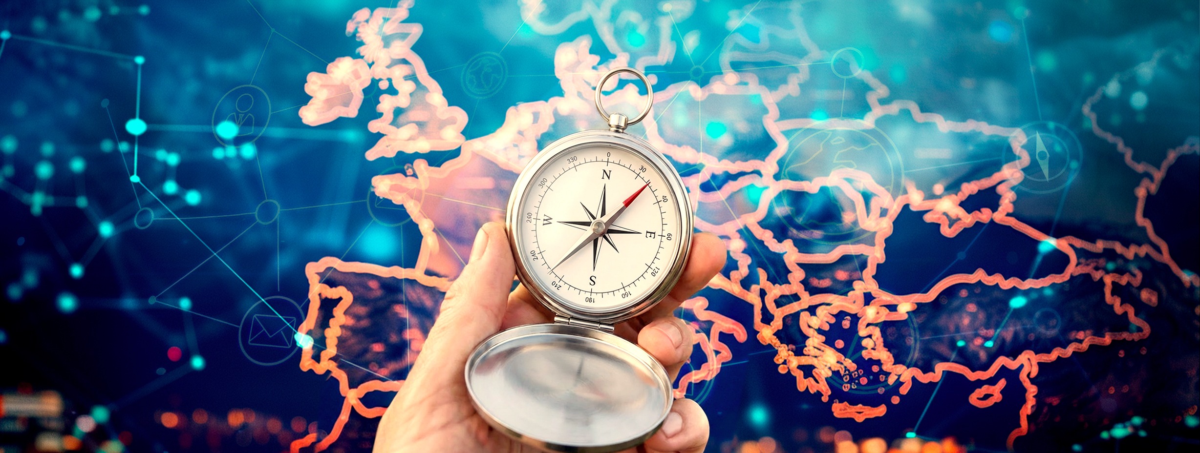 une main qui tien une boussole et derrière en arrière-plan c'est la carte de l’Europe